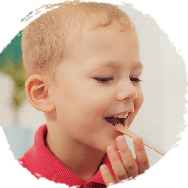 Chłopiec z patyczkiem medycznym w jamie ustnej